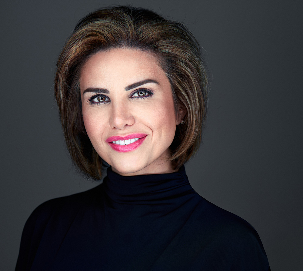Headshot of a woman with black turtle neck on a dark background